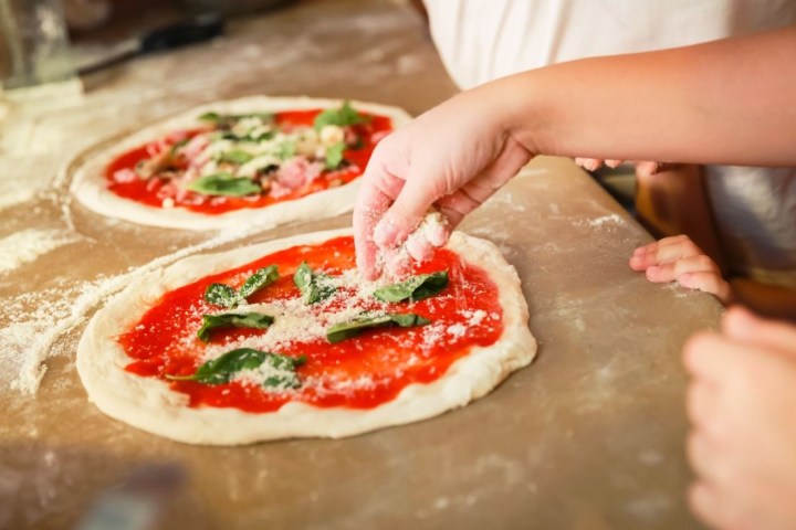 a person cutting a piece of pizza