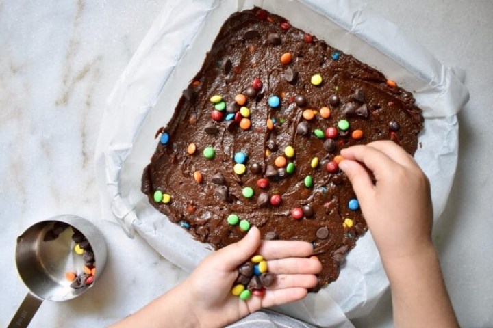a hand holding a chocolate cake