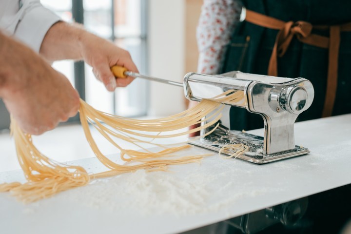 a person cutting a piece of cake on a table