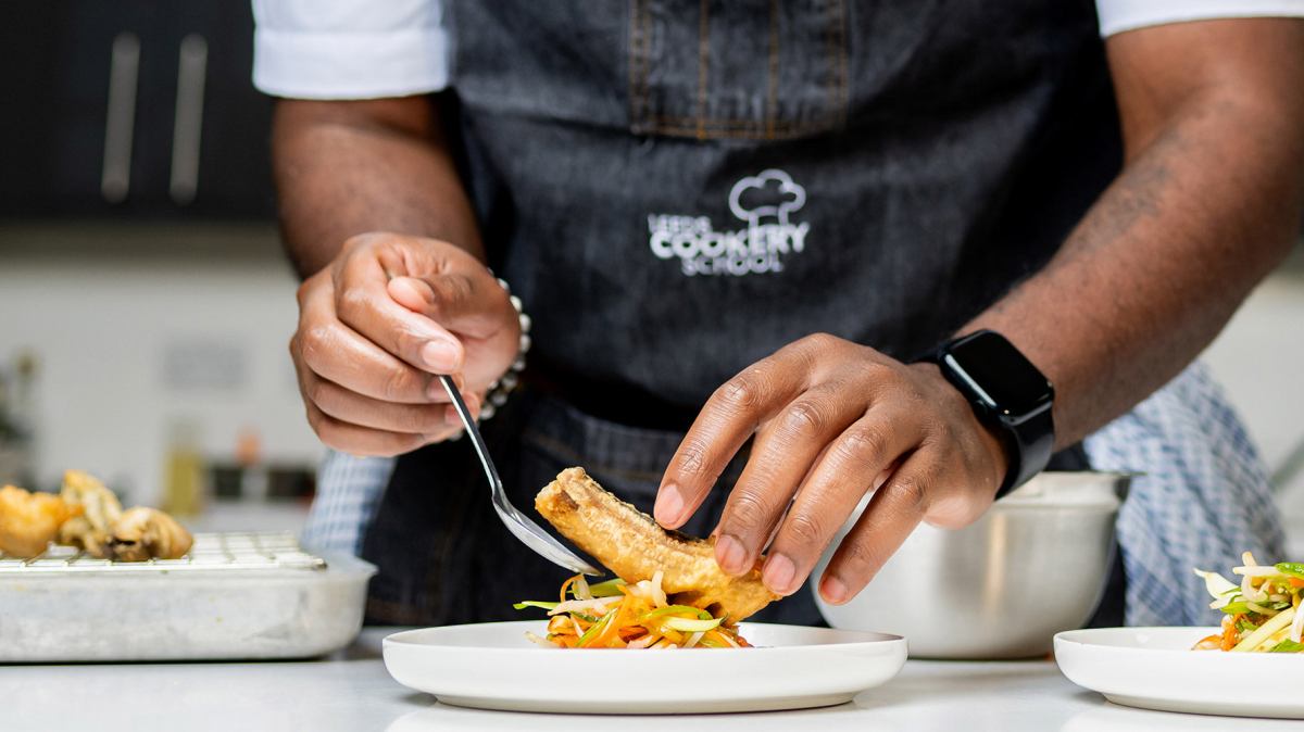 hands-serving-fish-narrow_5c41b5b9-f259-4a5e-b1b8-ab3b290da428 a man cutting food on a plate